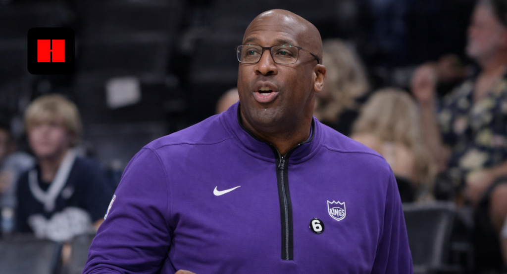 NBA coach in purple jacket giving instructions during basketball game sideline action
