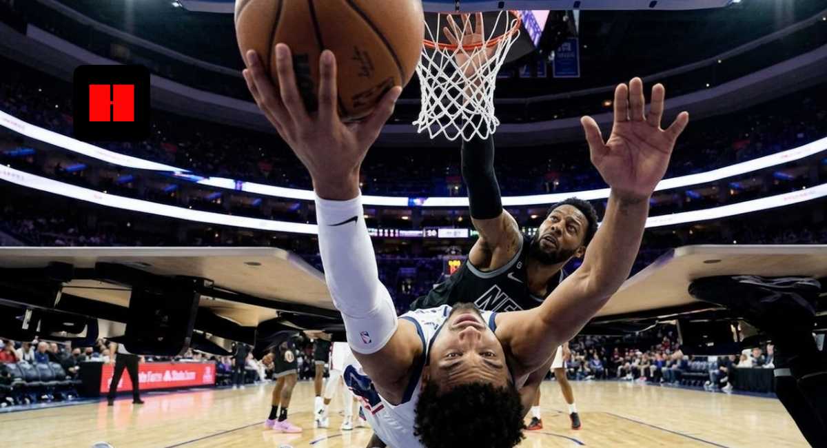 NBA player attempting a reverse layup under the basket while a defender contests the shot during a live game inside a packed arena.