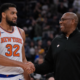 New York Knicks player standing with coach courtside during an NBA basketball game