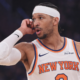 New York Knicks basketball player wearing white headband dribbling ball during NBA game action