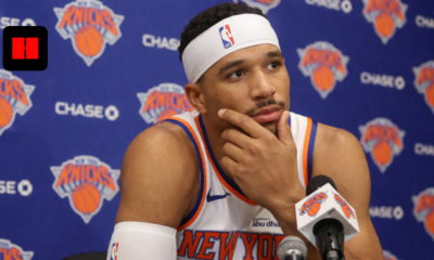 New York Knicks player speaking at a press conference with microphones during NBA media day