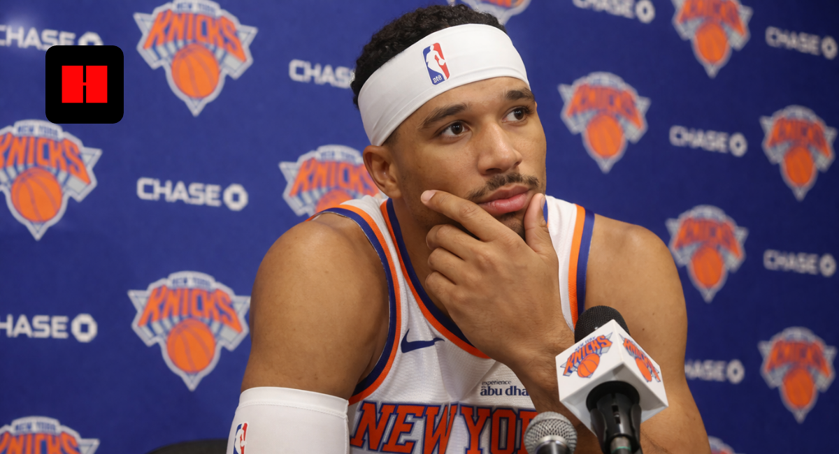 New York Knicks player speaking at a press conference with microphones during NBA media day
