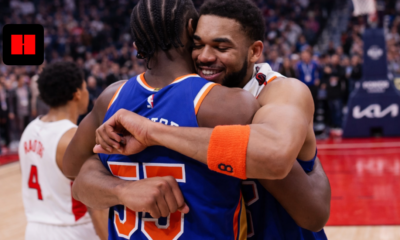 New York Knicks players hugging and celebrating together on the basketball court after the game
