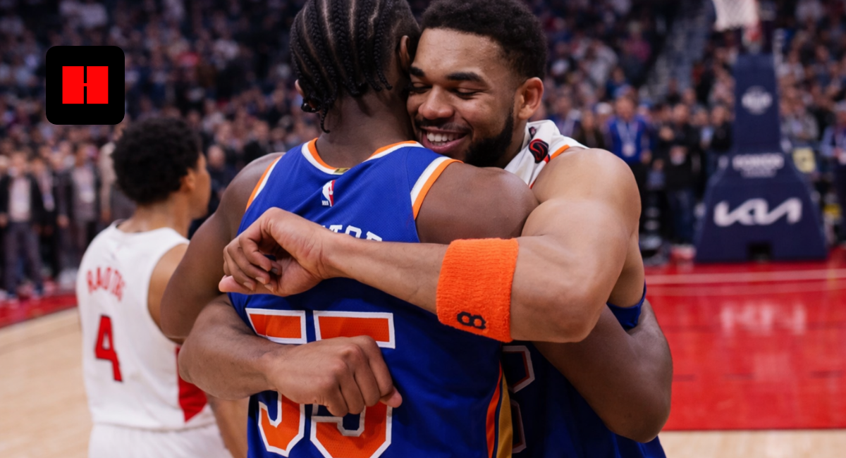 New York Knicks players hugging and celebrating together on the basketball court after the game