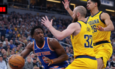 New York Knicks player driving to the basket while Indiana Pacers defenders attempt to block during an NBA game