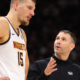 Nikola Jokic listens to Nuggets coach David Adelman during in-game sideline discussion