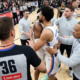 Oklahoma City Thunder's Chet Holmgren and Shai Gilgeous-Alexander being held back by officials and coaches during an intense NBA game moment.