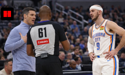 Oklahoma City Thunder player Alex Caruso standing near coach and referee during NBA game discussion on court