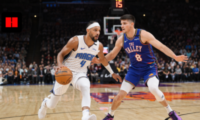 Orlando Magic player driving past Phoenix Suns defender during intense NBA basketball game