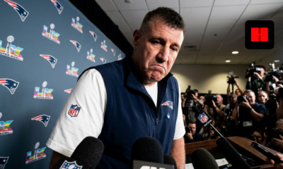 New England Patriots coach speaks to media during Super Bowl press conference with microphones and reporters gathered around