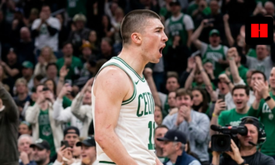 Boston Celtics guard Payton Pritchard shouting in celebration during a home game at TD Garden, side profile view.