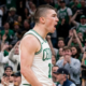 Boston Celtics guard Payton Pritchard shouting in celebration during a home game at TD Garden, side profile view.