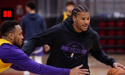 Phoenix Suns player dribbling basketball during indoor practice session with defender in training gym.