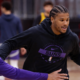 Phoenix Suns player dribbling basketball during indoor practice session with defender in training gym.