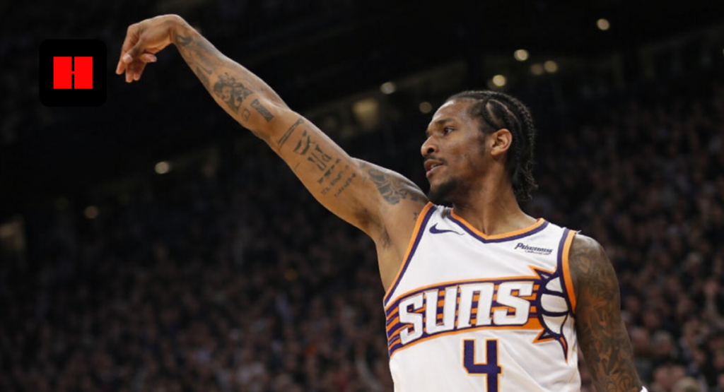 Phoenix Suns basketball player taking a jump shot captured from a low angle during an NBA game with crowd in background

