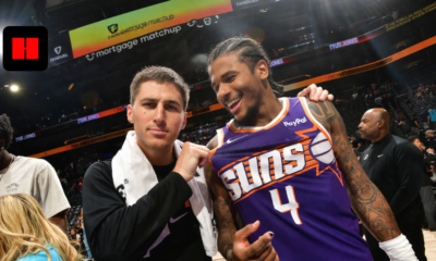 Phoenix Suns players smiling after game on basketball court with fans in arena UHD