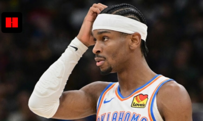 Shai Gilgeous-Alexander of the Oklahoma City Thunder wearing a white home jersey and headband, looking thoughtful on the court.
