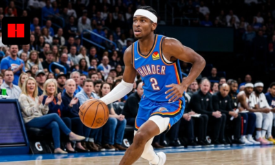 Shai Gilgeous-Alexander in a blue Oklahoma City Thunder jersey dribbling a basketball during an NBA game.