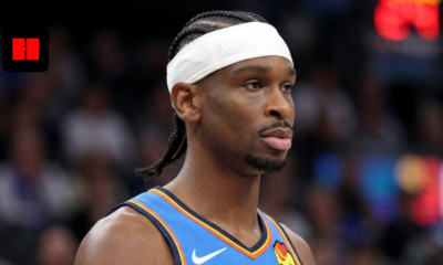 Close-up portrait of Shai Gilgeous-Alexander wearing a blue Oklahoma City Thunder jersey and white headband during a game.
