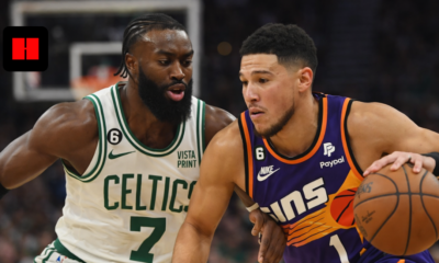 Phoenix Suns guard Devin Booker driving the ball against Boston Celtics forward Jaylen Brown in an NBA game.