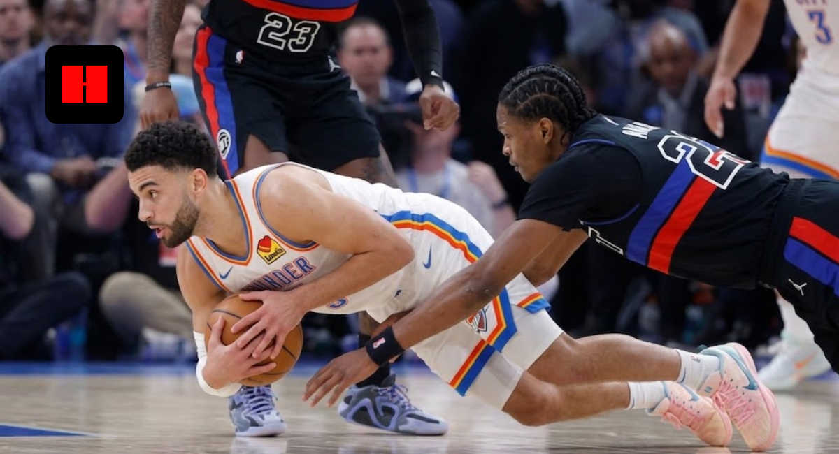 OKC Thunder player diving on the court to protect a loose ball against a Detroit Pistons defender during an NBA game.