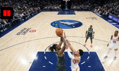 Minnesota Timberwolves player attempts contested layup over Phoenix Suns defender during NBA game at Target Center.