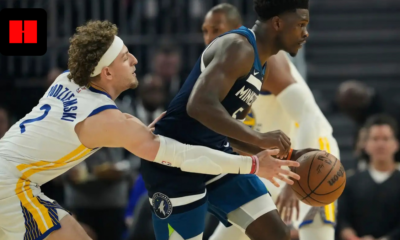 Golden State Warriors center Trayce Jackson-Davis defends Minnesota Timberwolves guard Anthony Edwards as he dribbles the ball during an NBA game.