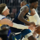 Golden State Warriors center Trayce Jackson-Davis defends Minnesota Timberwolves guard Anthony Edwards as he dribbles the ball during an NBA game.