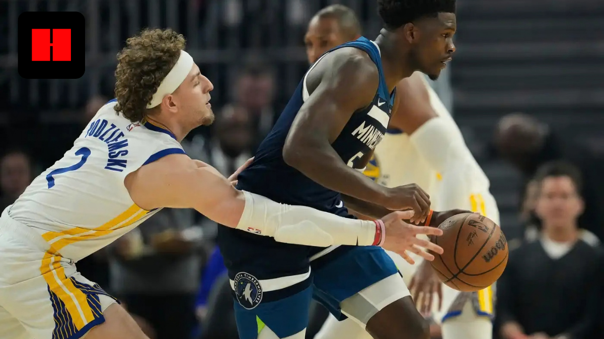 Golden State Warriors center Trayce Jackson-Davis defends Minnesota Timberwolves guard Anthony Edwards as he dribbles the ball during an NBA game.