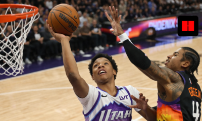 Utah Jazz player attempting a layup while Phoenix Suns defender contests the shot during an NBA game