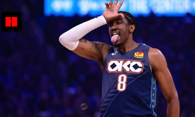 Oklahoma City Thunder forward Jalen Williams celebrating on court, wearing a navy blue City Edition jersey and white arm sleeve while making a playful "L" hand gesture and tongue-out expression.