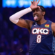 Oklahoma City Thunder forward Jalen Williams celebrating on court, wearing a navy blue City Edition jersey and white arm sleeve while making a playful "L" hand gesture and tongue-out expression.