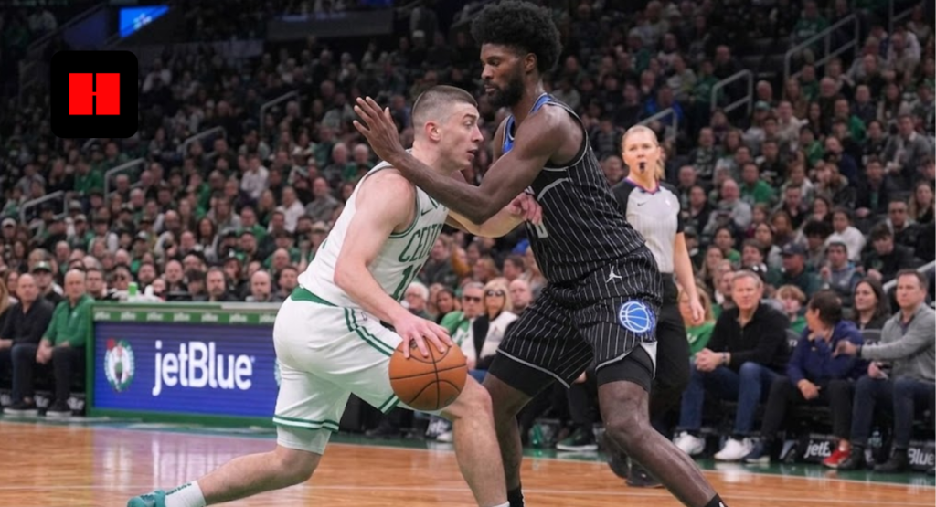 Boston Celtics guard Payton Pritchard dribbling the basketball while being defended by Orlando Magic forward Jonathan Isaac during a game.