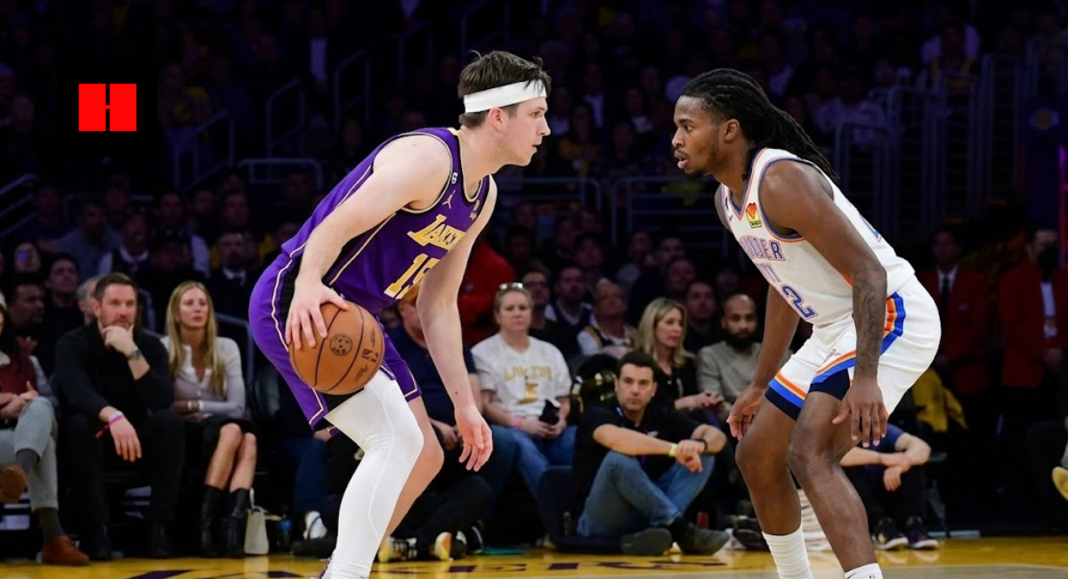 Side view of Austin Reaves in a Lakers purple jersey protecting the ball while being guarded by a Thunder player during a home game.