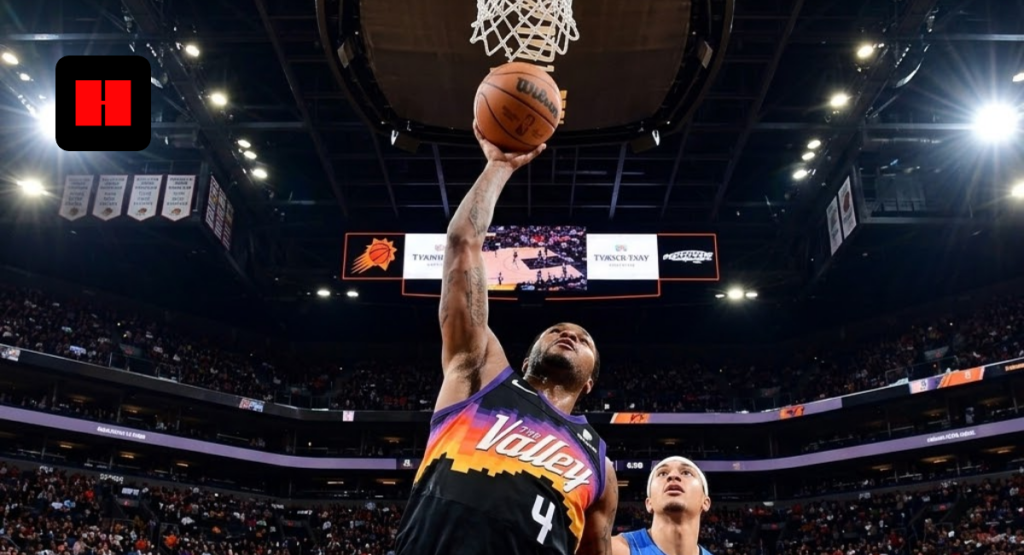Phoenix Suns guard Devin Booker shooting a layup over an Orlando Magic defender in a packed NBA arena.