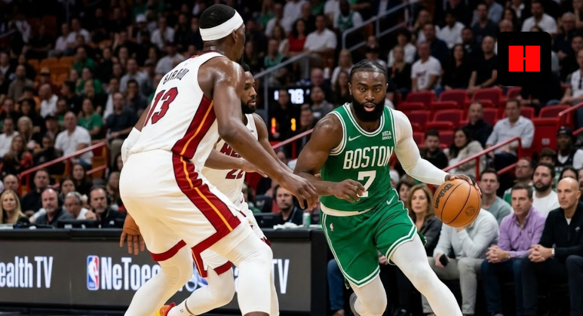 Jaylen Brown of the Boston Celtics dribbling the basketball past Bam Adebayo during an NBA game against the Miami Heat.
