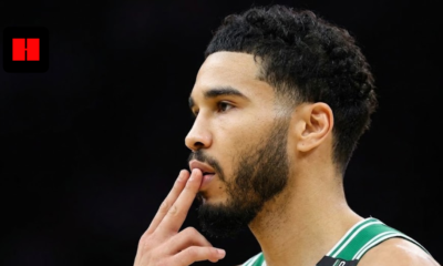 Jayson Tatum of the Boston Celtics in a side profile view on the basketball court, wearing a green and white jersey with fingers to his lips.