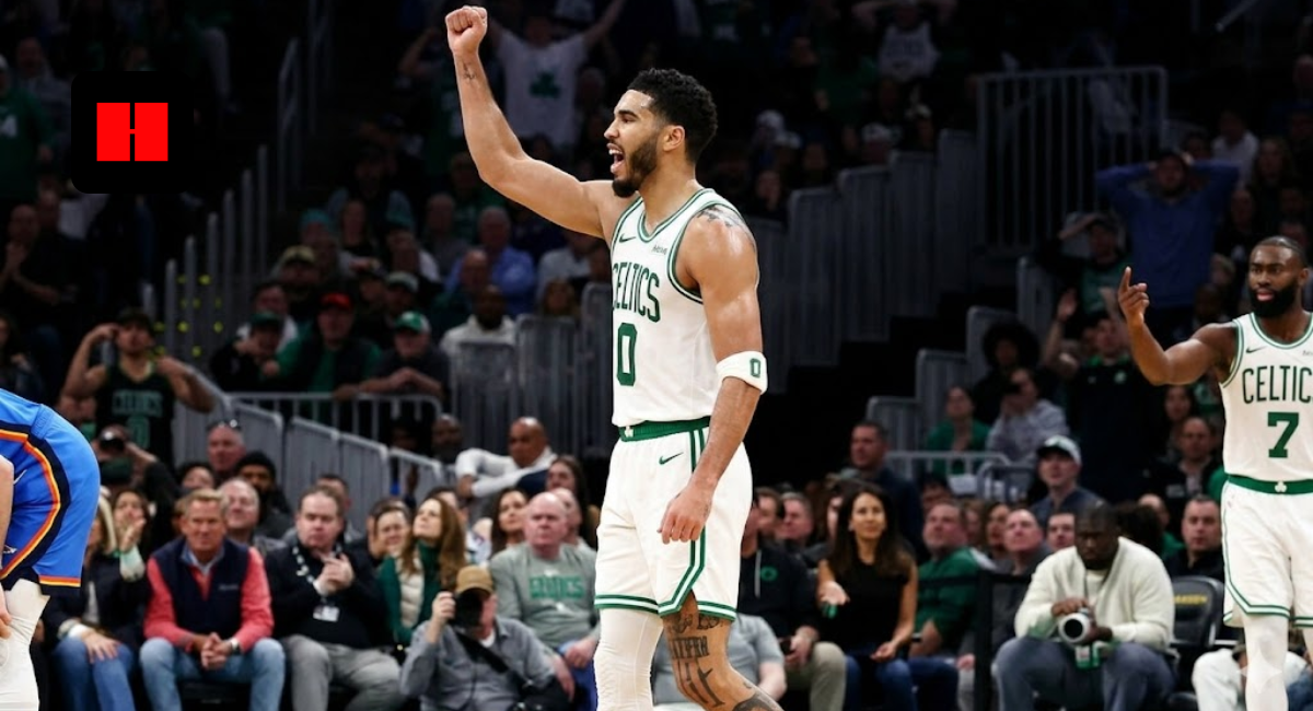 Boston Celtics forward Jayson Tatum (number 0) celebrating with a fist pump on the court during an NBA game, featuring Jaylen Brown in the background.