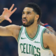 Boston Celtics forward Jayson Tatum (0) celebrating after making a three-point shot in a white Celtics jersey.