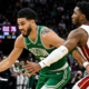 Jayson Tatum of the Boston Celtics driving to the basket while being guarded by Donovan Mitchell of the Cleveland Cavaliers during an NBA game.