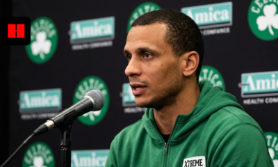 Boston Celtics head coach Joe Mazzulla speaking into a microphone during a press conference with Amica and Celtics logos in the background.