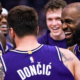 UHD side angle shot of Los Angeles Lakers players celebrating together during an NBA game with purple jerseys