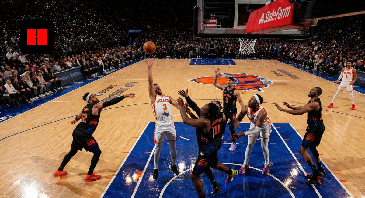 Wide-angle view of NBA basketball game showing Atlanta Hawks player attempting a rebound against New York Knicks defenders under the hoop in a packed arena