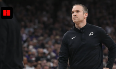 NBA coach standing courtside during Phoenix Suns game with focused expression and crowd in background