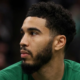 Profile shot of Jayson Tatum looking away, wearing a green Boston Celtics uniform with sponsorship logos