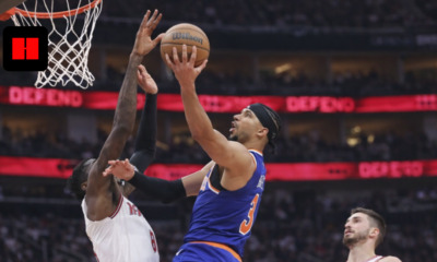 New York Knicks player attempts a layup while Houston Rockets defender tries to block during NBA game