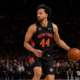 New York Knicks player dribbling the basketball during an NBA game on indoor court