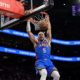 Alex Caruso of the Oklahoma City Thunder throws down a two-handed dunk against the Phoenix Suns during the 2026 NBA Playoffs game in Phoenix