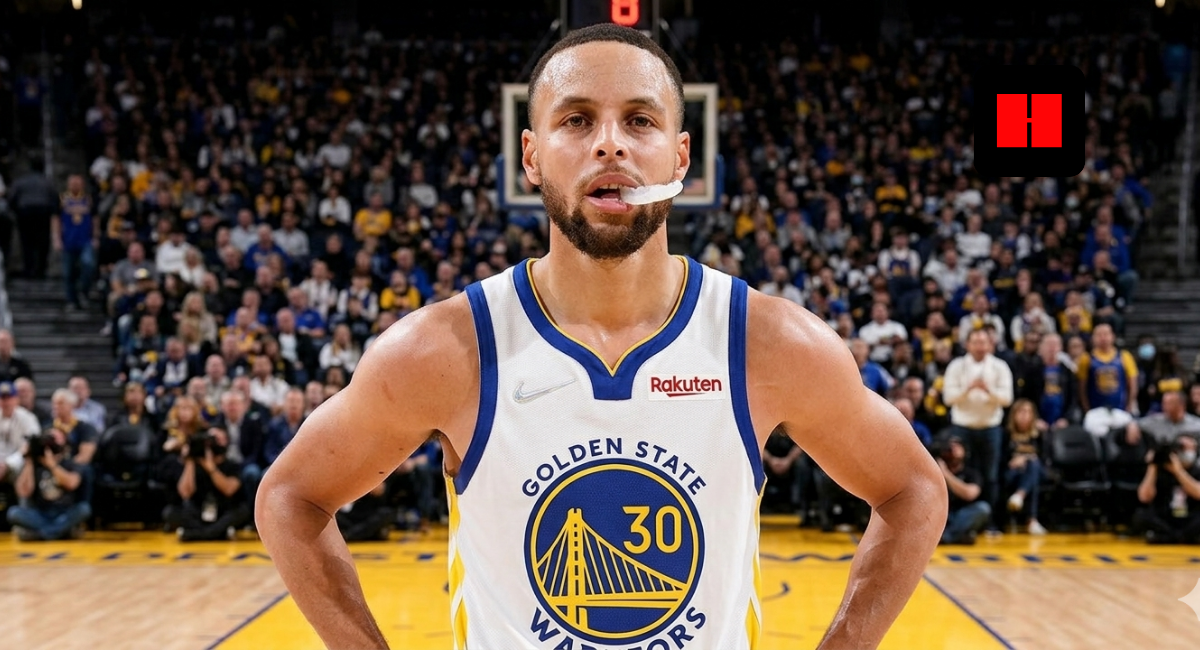 Stephen Curry standing on court in Golden State Warriors jersey with mouthguard out during home game action in 2026