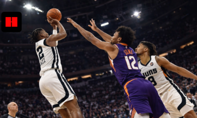 Utah Jazz player attempting a jump shot against Phoenix Suns defenders during an NBA game